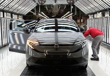 Employees inspect a finished car during a media tour of the Nissan Leaf electric car production line, at the Nissan factory in Sunderland, north-east England, on December 16, 2025. (Photo by Scott Heppell / AFP)