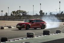 The Audi RS 5 Avant in Progressiv red on the Marrakech handling course: dynamic drifts demonstrating the plug‑in hybrid’s precise torque distribution.