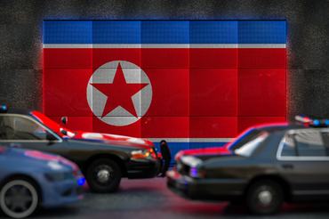 Bright digital display North Korea flag in city as cars drive past