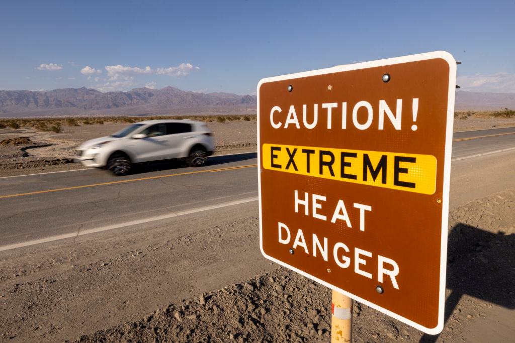DEATH VALLEY, CA - AUGUST 20: A car passes an extreme heat danger warning sign near Stovepipe Wells as Death Valley National Park partially reopens two weeks after record-setting rainfall caused a historic flash flood, on August 20, 2022 in Death Valley, California. Heavy rainfall from cloudbursts across Californias deserts have caused major damage in many areas. Death Valley National Park, Mojave National Preserve and Joshua Tree National Park are still recovering and only partially reopened. Park representatives said that the storm that shut down Death Valley on August 6 was a once in a thousand years event and could be the most widespread catastrophic event in the parks history, damaging 60 vehicles and trapping 1,000 people.  (Photo by David McNew/Getty Images)
