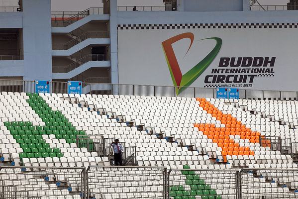 A security guard looks out from the spectator stands of the Buddh International Circuit, developed by Jaiprakash Associates Ltd. for the Formula One Grand Prix, in New Delhi, India, on Saturday, Oct. 22, 2011. India's inaugural Grand Prix will be held on Oct. 30. Photographer: Prashanth Vishwanathan/Bloomberg via Getty Images