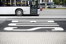 Bus lane on street with passing bus. Some minor motion blur