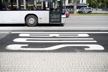 Bus lane on street with passing bus. Some minor motion blur