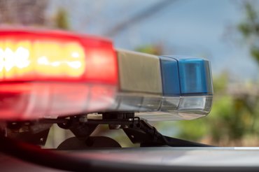 The emergency lights on a police vehicle of the New South Wales Police Force parked at the corner of Carrington Road and Pine Street, Randwick, at the scene of a motor vehicle accident.  This image was taken on a hot and sunny morning on 8 February 2025.