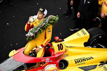 INDIANAPOLIS, INDIANA - MAY 25: #10, Alex Palou, Chip Ganassi Racing Honda drinks milk on the Podium after the NTT IndyCar Series 109th Running of the Indianapolis 500 at Indianapolis Motor Speedway on May 25, 2025 in Indianapolis, Indiana.  (Photo by Brandon Badraoui/Lumen via Getty Images)