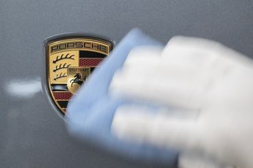 PRODUCTION - 06 March 2026, Baden-Württemberg, Stuttgart: A Porsche AG employee wipes a Porsche badge in a light tunnel in the production area at the main plant in Zuffenhausen. Photo: Marijan Murat/dpa (Photo by Marijan Murat/picture alliance via Getty Images)