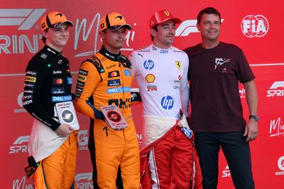 MIAMI, FLORIDA - MAY 02: Sprint winner Lando Norris of Great Britain and McLaren Second placed Oscar Piastri of Australia and McLaren and Third placed Charles Leclerc of Monaco and Scuderia Ferrari receive their Sprint trophies from Reid Wiseman during the Sprint ahead of the F1 Grand Prix of Miami at Miami International Autodrome on May 02, 2026 in Miami, Florida. (Photo by Ryan Pierse/LAT Images)