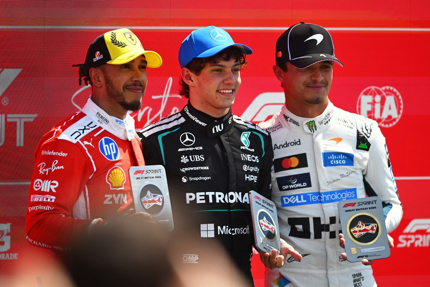 NORTHAMPTON, ENGLAND - JULY 04: Sprint winner Andrea Kimi Antonelli of Italy and Mercedes AMG Petronas F1 Team Second placed Lewis Hamilton of Great Britain and Scuderia Ferrari and Third placed Lando Norris of Great Britain and McLaren in parc ferme with their trophies during the Sprint ahead of the F1 Grand Prix of Great Britain at Silverstone Circuit on July 04, 2026 in Northampton, England. (Photo by Rudy Carezzevoli/Getty Images)