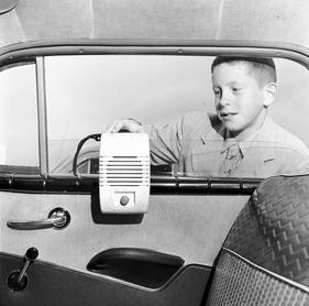 circa 1955: A young worshipper at a Protestant Council's Drive-In Church service at Bronx Whitestone Drive-In theatre, sets up his individual speaker in the family car. (Photo by Orlando /Three Lions/Getty Images)