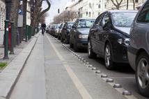 "Budapest, Hungary - March 14, 2011: Photography of bike lane next to parking cars. A biker is approaching in the distance. Taken in Budapest downtown."